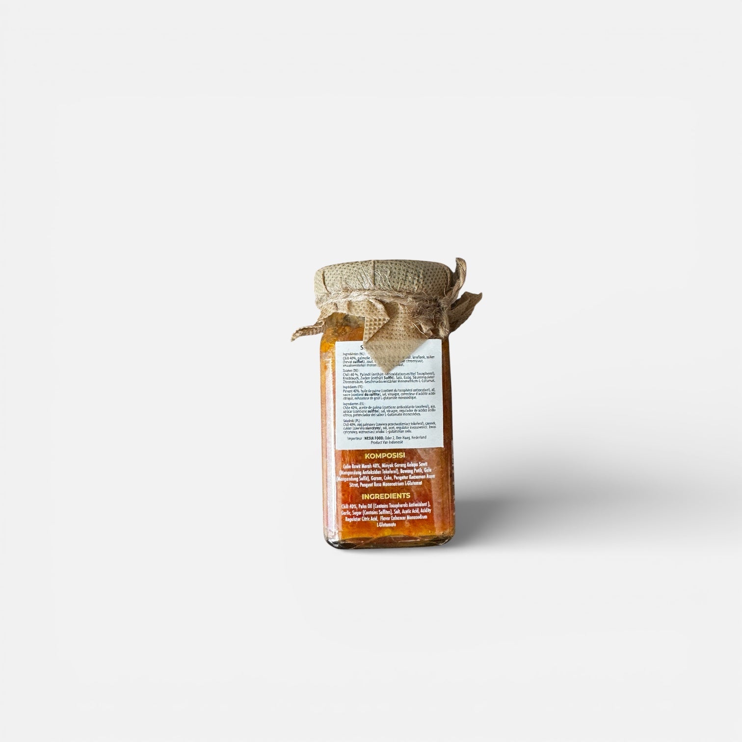 Chilisauce Otentik Sambal Bawang von Nesia in einer Glasflasche mit roter Chili- und Knoblauch-Zutaten.